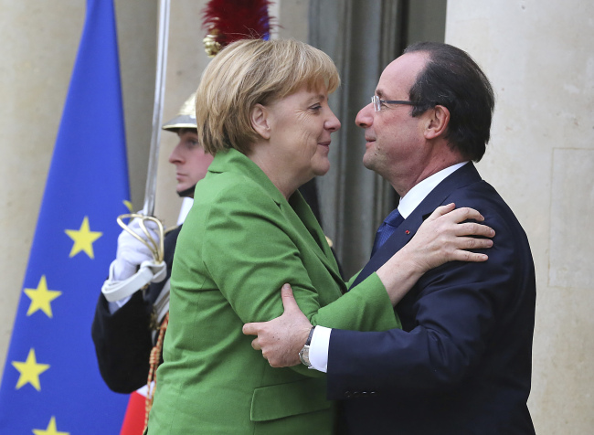 French President Francois Hollande (right) greets German Chancellor Angela Merkel at the Elysee Palace in Paris on Tuesday. (AP-Yonhap News)