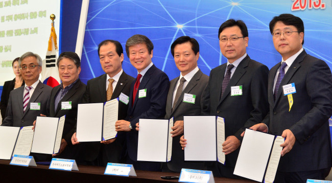 Representatives from large retailers and traditional markets, including Homeplus chairman Lee Seung-han (fourth from right) and company CEO Do Sung-hwan (second from right), pose after signing an agreement to promote shared growth at a ceremony at KINTEX, Goyang, Gyeonggi Province, Thursday. (Lee Sang-sub/The Korea Herald)