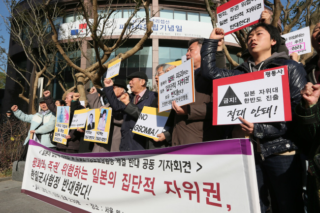 13일 오후 서울 중구 소공동 웨스틴조선호텔 앞에서 열린 `일본의 집단적 자위권 및 한일군사정보보호협정 체결반대 공동기자회견`에서 참가자들이 한일군사협정을 반대하는 구호를 외치고 있다. (연합뉴스)