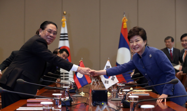 Presidents Park Geun-hye of South Korea and Choummaly Sayasone of Laos shake hands at summit talks at Cheong Wa Dae, Friday. (Yonhap News)