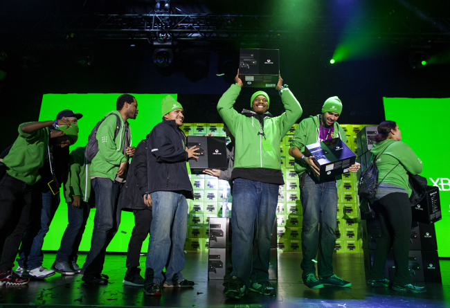 Several of the first 10 people to purchase the Microsoft Xbox One game system exalt in the moment as they receive their console at an event in New York on Friday. (AP-Yonhap News)