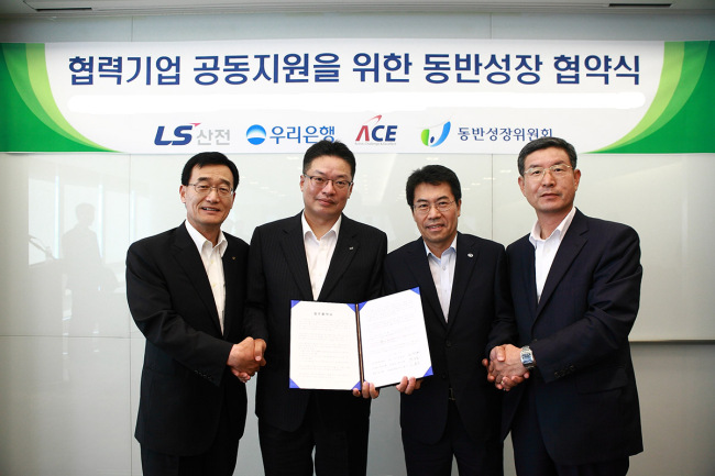 Representatives from LSIS, its sub-contractor Buwon, Woori Bank and the government pose at a ceremony to sign an agreement for shared growth in August. (LSIS)