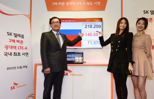 Choi Jin-sung (left), head of the ICT R&D Division of SK Telecom, Yuna from Girls’ Generation (second from left) and Sulli from f(x) attend an event to demonstrate the company’s new network technology service in Bundang, Gyeonggi Province, Thursday. (Park Hae-mook/The Korea Herald)