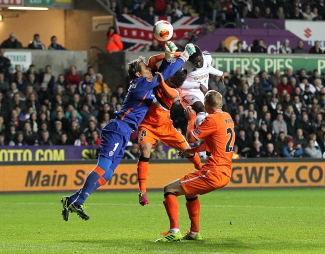 COLLISION: Valencia’s goalkeeper Carreira Diego Alves (left) makes a save against Swansea City during a Europa League Group A match on Thursday. Valencia won 1-0. (AP-Yonhap News)