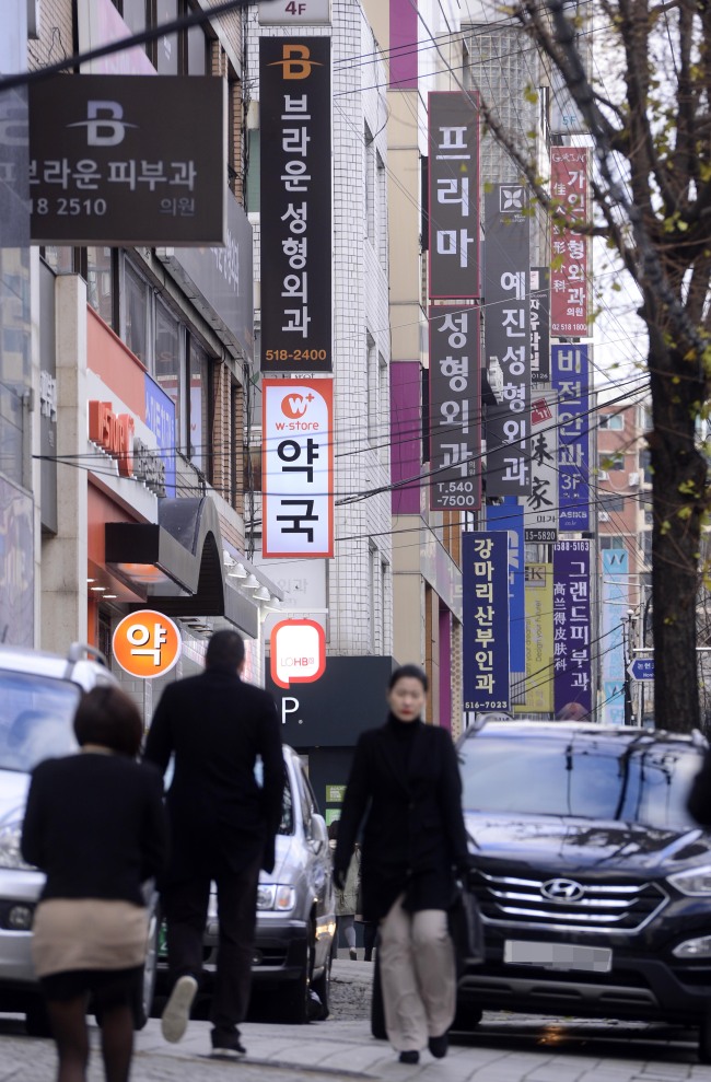 People walk down a street lined with cosmetic surgery clinics in Apgujeong-dong in Seoul. The clinics shown in the photo are not related to this article. (Park Hae-mook/The Korea Herald)