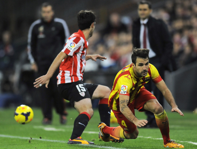 Barcelona’s Francesc Fabregas (right) is tackled by Athletic Bilbao’s Andoni Iraola on Sunday. (AP-Yonhap News)