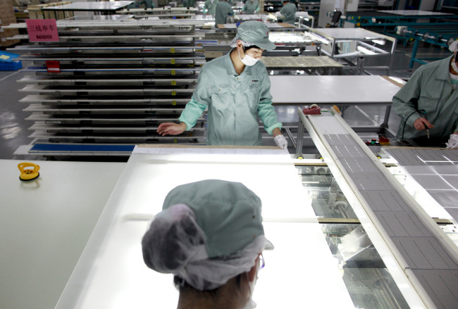 Employees assemble photovoltaic panels at Suntech Power Holdings Co.’s factory in Wuxi, Jiangsu province, China. (Bloomberg)