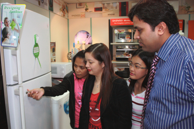 Customers look at a refrigerator with a door lock in Dubai, UAE. (Dongbu Daewoo Electronics)