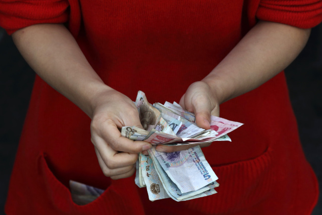 A vendor counts yuan notes at her stall in Wuhan, China. (Bloomberg)