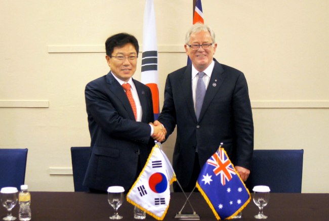 Korea’s Trade Minister Yoon Sang-jick (left) meets his Australian counterpart Andrew Robb in Bali, Indonesia, Wednesday, to discuss a free trade agreement between their two countries. (Trade Ministry)