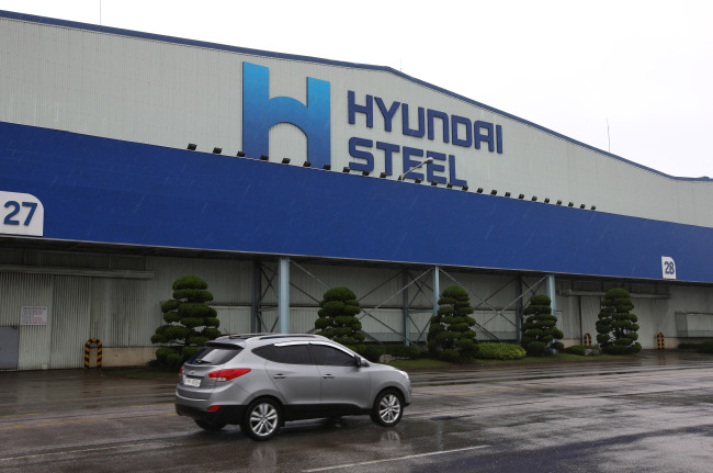 A car drives past the Hyundai Steel Co. plant in Dangjin, South Chungcheong Province. (Bloomberg)