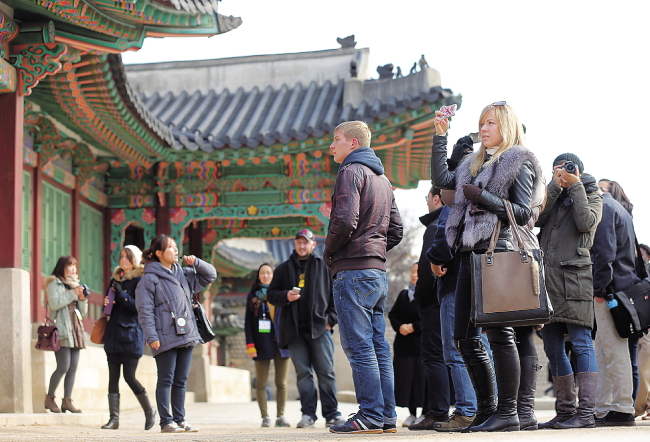 Foreign tourists take a guided tour of Changdeokgung Palace in Seoul on Tuesday. The number of foreign tourists surpassed 10 million in October, a month sooner than last year. (Yonhap News)
