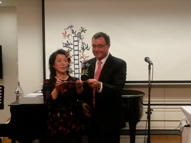 Israeli Ambassador to South Korea Uri Gutman (right) presents a sculpture depicting angels ascending and descending a ladder to heaven in the “Jacob’s Ladder” scene of the book of Genesis in the Jewish holy Torah during a Hanukkah celebration at the Israeli Culture Center in Seoul, on Nov. 28.  (Philip Iglauer/The Korea Herald)