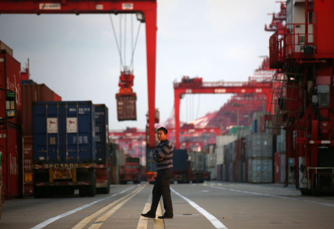 A man walks past shipping containers at the Yangshan Deep Water Port in Shanghai. (Bloomberg)