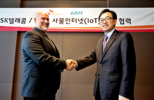 The head of SK Telecom’s ICT division Choi Jin-sung (right) meets with ARM’s vice president Adam Gould for joint research on Internet of Things technology. (SKT)