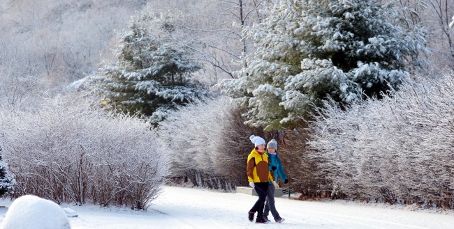 Citizens stroll through Nanjicheon Park in northwest Seoul on Wednesday after 3 to 6 centimeters of snow fell in central parts of the country. (Kim Myung-sub/The Korea Herald)