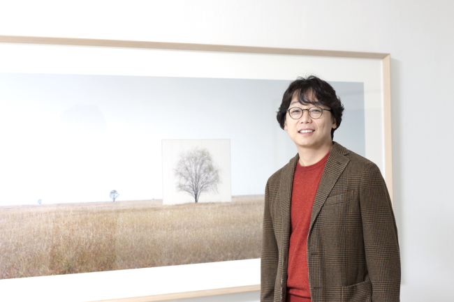 Artist Lee Myung-ho poses for a photo with his work, on display at Gallery Hyundai. (Gallery Hyundai)