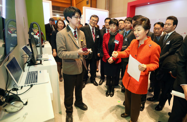 President Park Geun-hye looks at a remote control for a speaker system developed by a high school student at Creative Korea 2013 at the Coex mall, Seoul, Thursday. (Yonhap News)