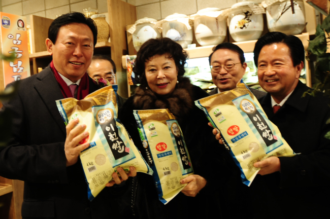 Lotte Group chairman Shin Dong-bin (left) and other participants hold packs of rice harvested in Icheon, Gyeonggi Province, during a ceremony to open Asia’s largest premium outlet in the city on Friday. From left: Shin, Lotte Foundation chairwoman Shin Young-ja, Lotte Department Store CEO Shin Heon and ruling party lawmaker Yoo Seung-woo. (Lotte Department Store)