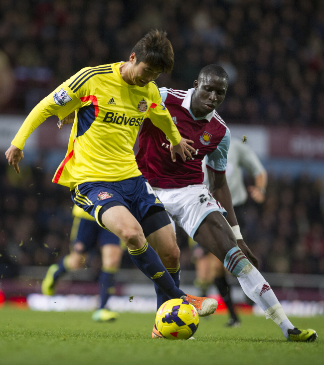 Sunderland’s Ki Sung-yueng (left) and West Ham’s Mohamed Diame battle for the ball on Saturday. (AP-Yonhap News)