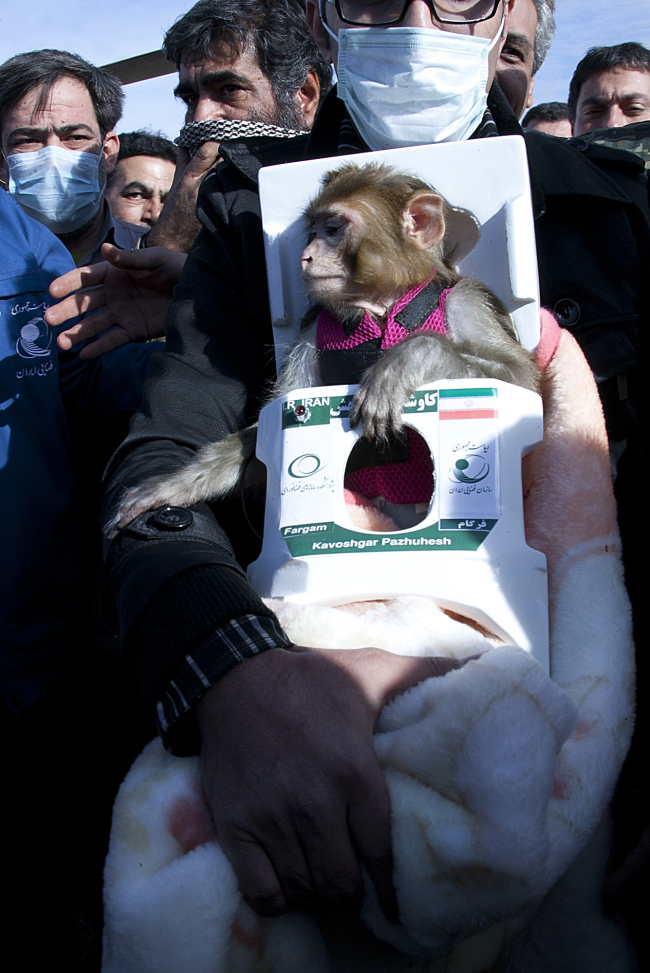 A man carries a monkey named Fargam during a mission to send it into space on Saturday. (AP-Yonhap News)