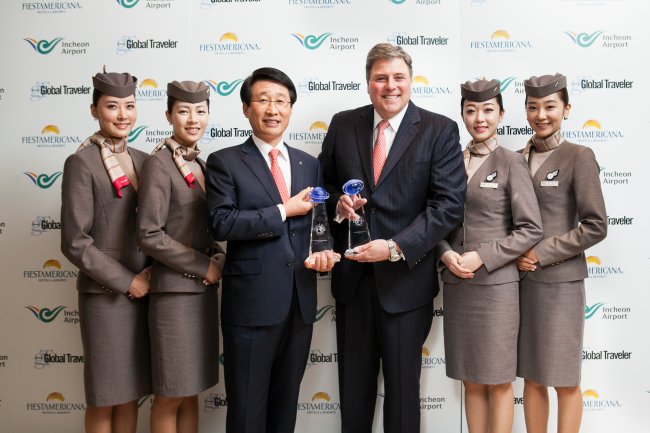 Han Tae-keun, executive vice president of corporate support at Asiana Airlines (third from left) poses with Francis Gallagher (third from right), CEO and publisher of Global Traveler, and Asiana flight attendants at Peninsula Beverly Hills Hotel in Los Angeles on Wednesday. Asiana Airlines received the Best Airline Onboard Service and Best Airline for Flight Attendants awards from Global Traveler magazine for the 10th straight year. (Asiana Airlines)