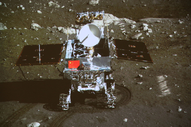 In this image taken by the on-board camera of the lunar probe Chang’e-3 and made off the screen of the Beijing Aerospace Control Center in Beijing, China’s first moon rover ‘Yutu’ - or Jade Rabbit - is on the lunar surface in the area known as Sinus Iridum (Bay of Rainbows) Sunday. (AP-Yonhap News)