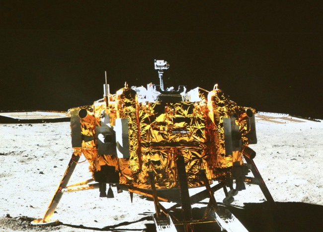 In this image made off the screen at the Beijing Aerospace Control Center in Beijing, is the Chang’e-3 moon lander, taken by the camera on the ‘Yutu’ (Jade Rabbit) moon rover, during the mutual-photograph process in the area known as Sinus Iridum (Bay of Rainbows), Sunday