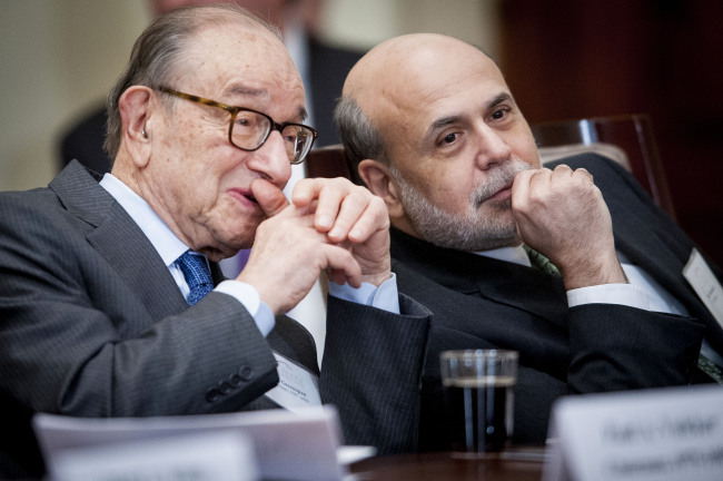 Alan Greenspan (left), former chairman of the U.S. Federal Reserve, chats with Ben Bernanke, the current Fed chairman, during an event commemorating the Federal Reserve Act, the legislation that created the central bank, in Washington on Monday. (Bloomberg)