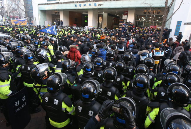 Police officers prepare to storm into a union office on Sunday. (Yonhap News)