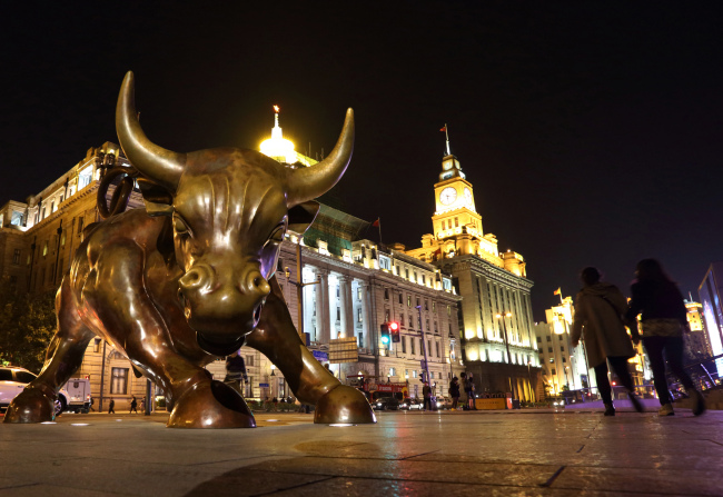 Pedestrians walk past Arturo Di Modica’s “The Bund Financial Bull” sculpture on the Bund in Shanghai. (Bloomberg)