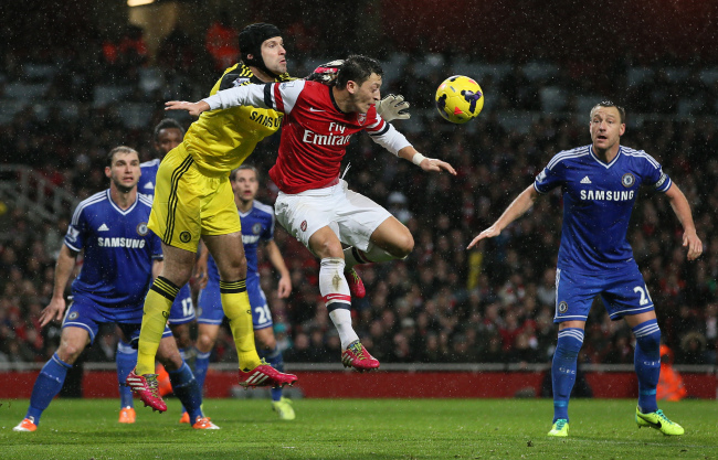 Chelsea goalkeeper Petr Cech punches the ball clear while under pressure from Arsenal’s Mesut Ozil on Monday. (AP-Yonhap News)