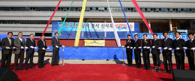 Korea Electric Power Corp. CEO Cho Hwan-eik (fifth from left) and other participants attend the ceremony to mark the completion of the framework of the headquarters building under construction in Naju, South Jeolla Province, Tuesday. KEPCO plans to move to the city in November next year. (KEPCO)