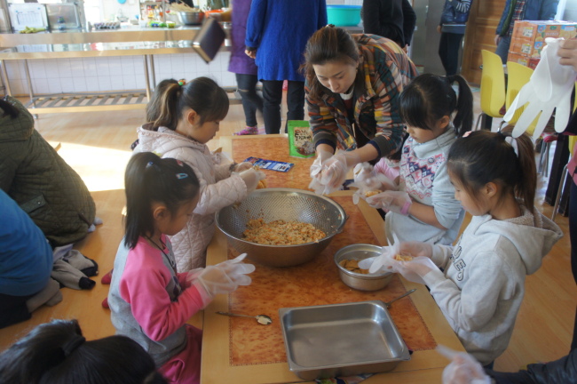 An employee at Samsung Fire & Marine Insurance, Changwon division, prepares lunch with underprivileged children at a welfare facility in South Gyeongsang Province. (Samsung Fire & Marine Insurance)