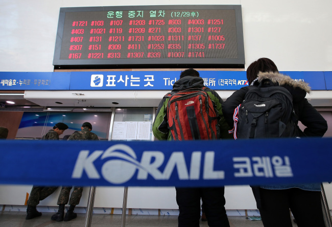 People wait in a line at the Seoul Railway Station in Seoul on Sunday. Korea Railroad Corp.’s labor union continued its strike for a 21st consecutive day. (Yonhap News)