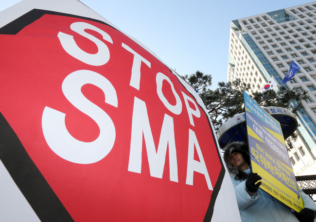 한국과 미국이 내년 이후 적용할 방위비분담 특별협정(SMA) 체결을 위한 '제9차 고위급 협의'를 연 11일 오전 서울 종로구 세종로 외교부 청사 앞에서 평화와통일을여는사람들 회원들이 미군주둔비 삭감과 협정 전용 금지 명시를 주장하며 피켓시위를 하고 있다. (연합뉴스)