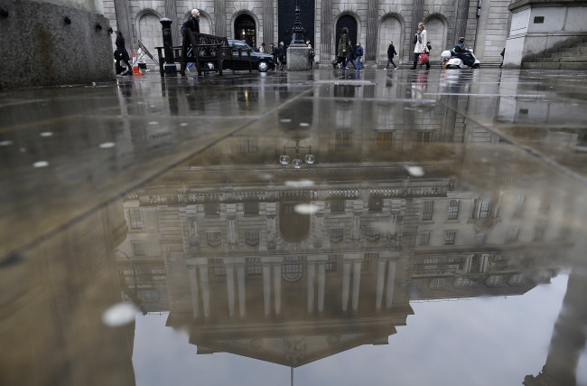 Pedestrians pass the main entrance to the Bank of England in London. (Bloomberg)