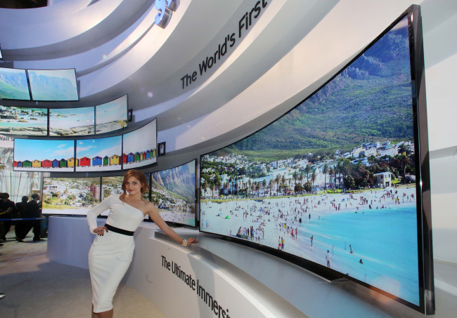 A model showcases Samsung Electronics’ 105-inch curved UHD TVs during the 2014 International CES in Las Vegas on Thursday. (Samsung Electronics)