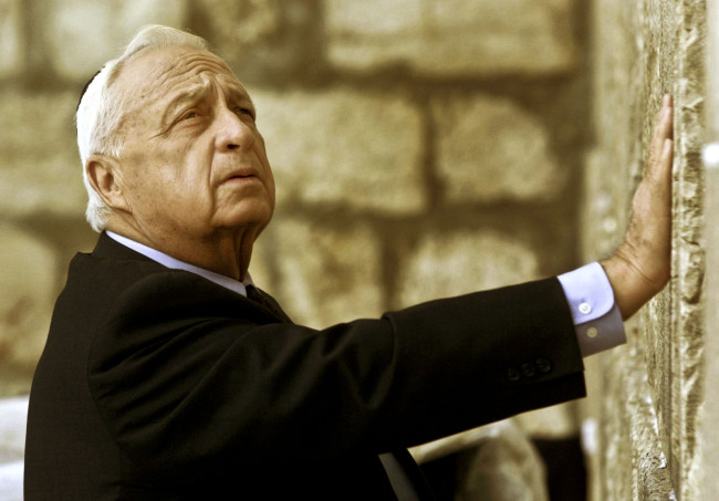 In this Feb. 7, 2001, file photo, Ariel Sharon looks up as he touches Judaism’s holiest site, the Western Wall.(AP-Yonhap News)