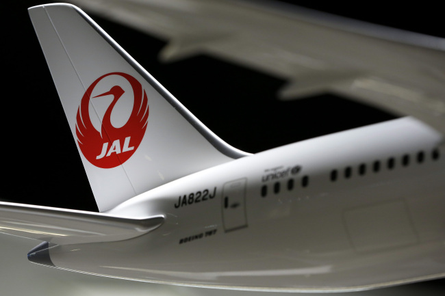 The Japan Airlines Co. logo sits on the tailfin of a model of the Boeing Co. 787 Dreamliner aircraft. (Bloomberg)