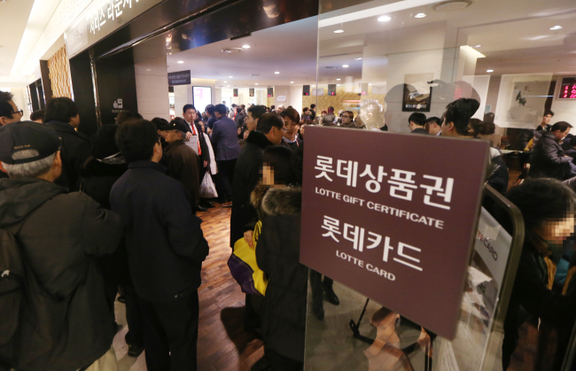 Customers wait to have their credit cards reissued to prevent losses from a leak of personal information at the Lotte Card Center in a branch of Lotte Department Store in Seoul on Monday. (Yonhap News)