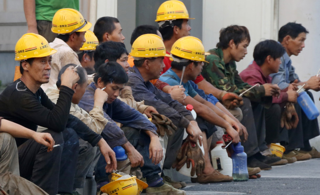 Workers take a break outside a construction site in Shanghai. (Bloomberg)