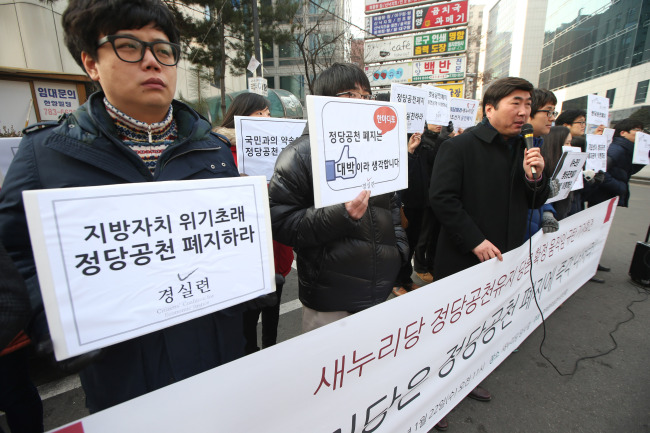 Members of the nongovernmental group Citizens’ Coalition for Economic Justice hold a rally calling for the abolishment of the candidate nomination system outside the Saenuri Party’s office in Seoul on Wednesday. (Yonhap News)