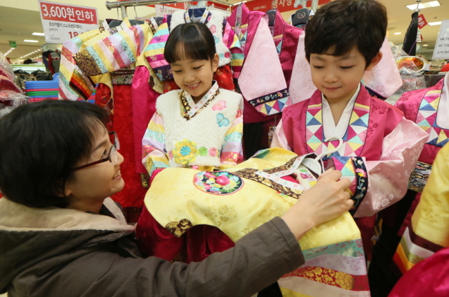 A customer shops for hanbok for her children at Lotte Mart Seoul Station ahead of the Lunar New Year holiday. While fewer adults wear the traditional Korean clothes, the demand for children’s hanbok continues. (Yonhap)