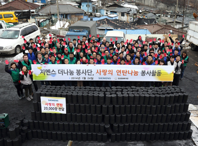 The Nanum, an in-house volunteer group at Siemens Korea, helped distribute coal briquettes in Junggyebon-dong, Seoul, Friday. (Siemens Korea)