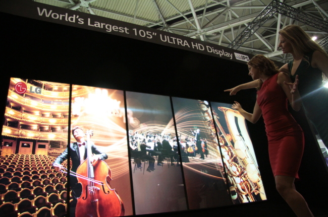 Models pose with LG Electronics’ 105-inch curved ultra HD TV displayed at Integrated Systems Europe, a commercial display trade show held in Amsterdam from Tuesday to Thursday. (LG Electronics)