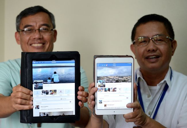 Philippine Bishop of San Pablo, Laguna, Buenaventura Famadico (left) and Auxillary Bishop of San Fernando, Pampanga, Roberto Mallari show their Facebook accounts on their tablets at the Pope Pius XII Catholic Center in Manila on Jan. 22. (AFP-Yonhap)