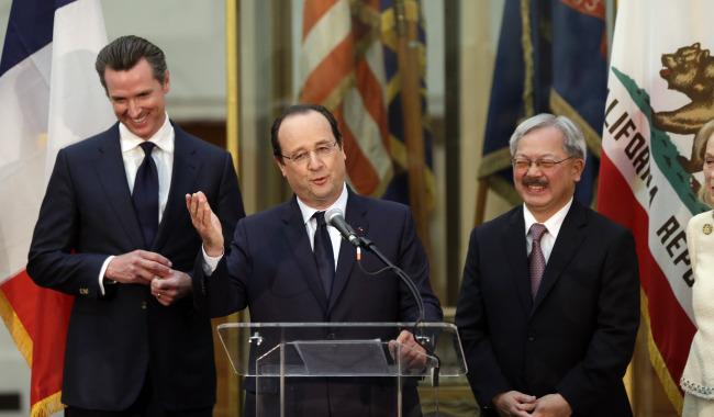 French President Francois Hollande speaks as California Lt. Gov. Gavin Newsom (left) and San Francisco Mayor Ed Lee listen in during a visit to city hall in San Francisco on Wednesday. (AP-Yonhap)