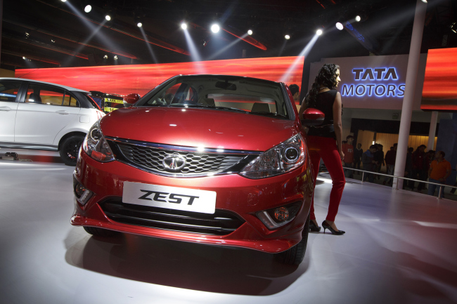 A model poses with a Tata Motors Zest vehicle during the 12th Auto Expo 2014 in Noida, India, on Feb. 7. (Bloomberg)