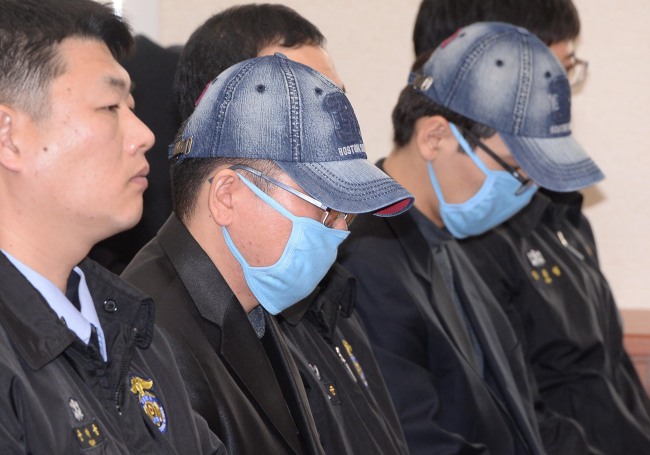 A Korea Credit Bureau employee surnamed Park (right), who allegedly stole personal data from credit card companies, and an ad agency official only identified as Cho (center), who purchased the stolen data, attend a hearing in a parliamentary probe by the National Policy Committee of the National Assembly in Seoul on Tuesday. The two suspects were arrested after a massive data leak concerning some 20 million clients at KB Kookmin Card, Lotte Card and NH NongHyup Card last month. (Lee Gil-dong/The Korea Herald)